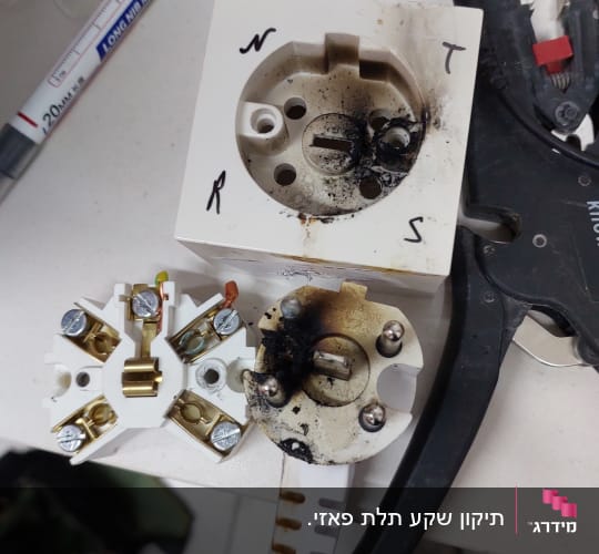 שקע חשמלי שרוף עם חוטים וכלים